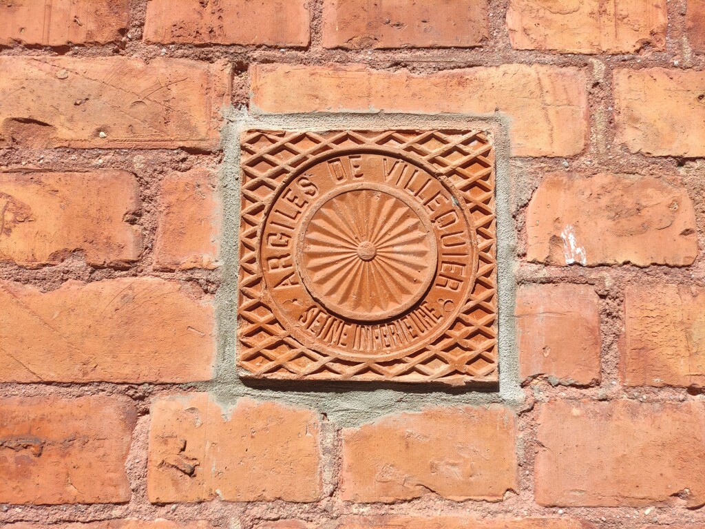 ensemble des productions pour bâtiment des Etablissements Céramiques de Villequier ; Carreau de pavement inséré sur la façade d'une maison. Face arrière portant l'inscription : Argiles de Villequier.- Maison en brique de Villequier, rue Ernest Binet.
